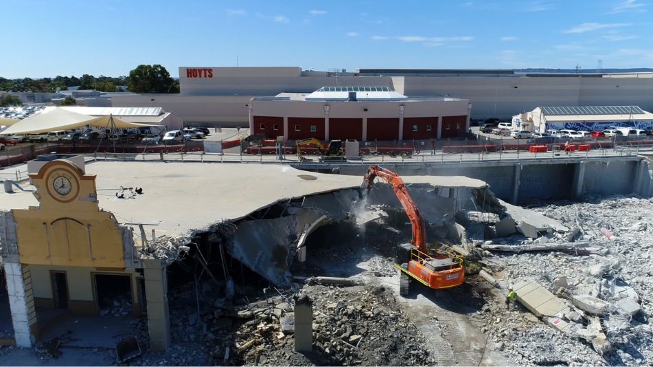 Commercial site demolition project undertaken by Focus Demolition in Perth showing a excavator in work surrounded by rubble.