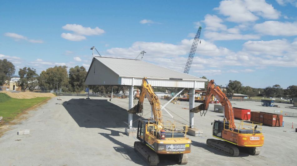 Two heavy machinery vehicles demolishing at the RAAF Pearce Aircraft Shelter in Bullsbrook by Focus Demolition