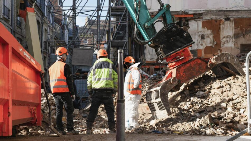 A Perth crew at work next to a large piece of machinery stuck in rubble. Featured on the Focus Demolition Contact Us page.