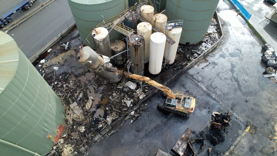 Close shot of an excavator at work at the Sami Bitumen Plant in North Fremantle demolishing an aging tank as part of Focus Demolition.