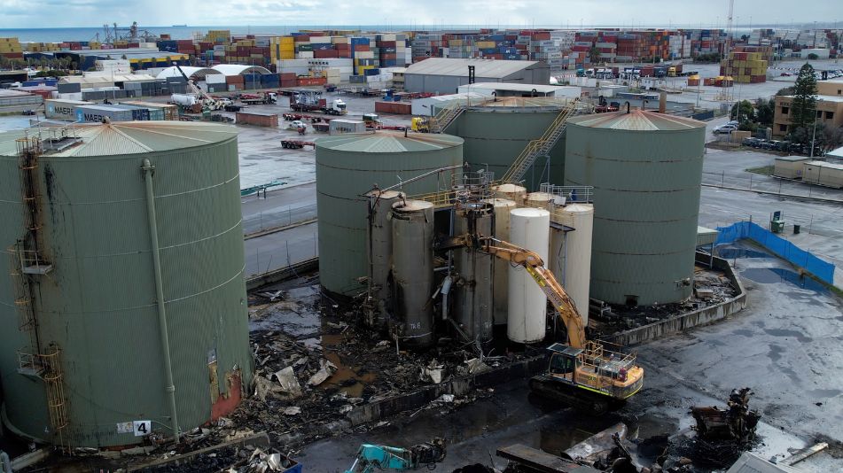 Detailed wide shot of a Focus Demolition excavator at work at the Sami Bitumen Plant in North Fremantle demolishing an aging tank.