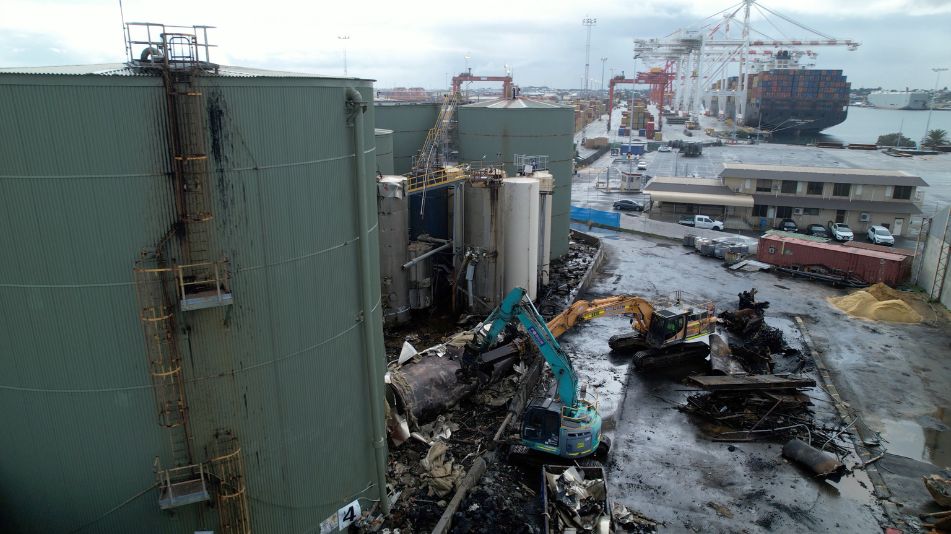 The aged tank at the Sami Bitumen Plant at North Fremantle tipped over by two excavators doing demolishing work.