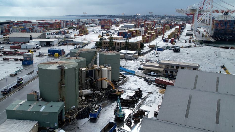 A wide shot of the aging tanks at the Sami Bitumen Plant in North Fremantle being demolished by a Focus Demolition by excavator.