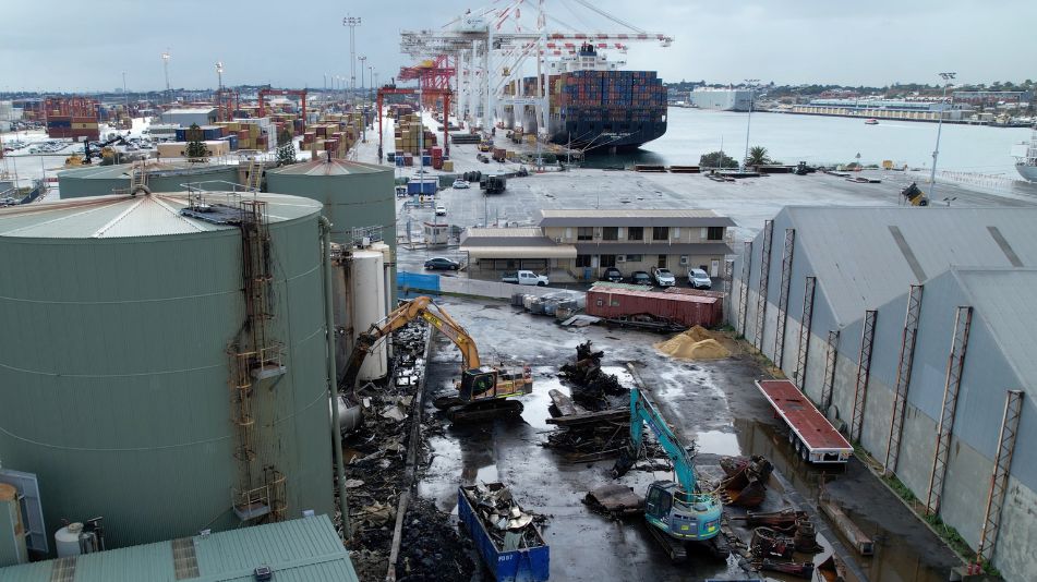 Wide shot of an excavator at work at the Sami Bitumen Plant in North Fremantle demolishing an aging tank as part of Focus Demolition.